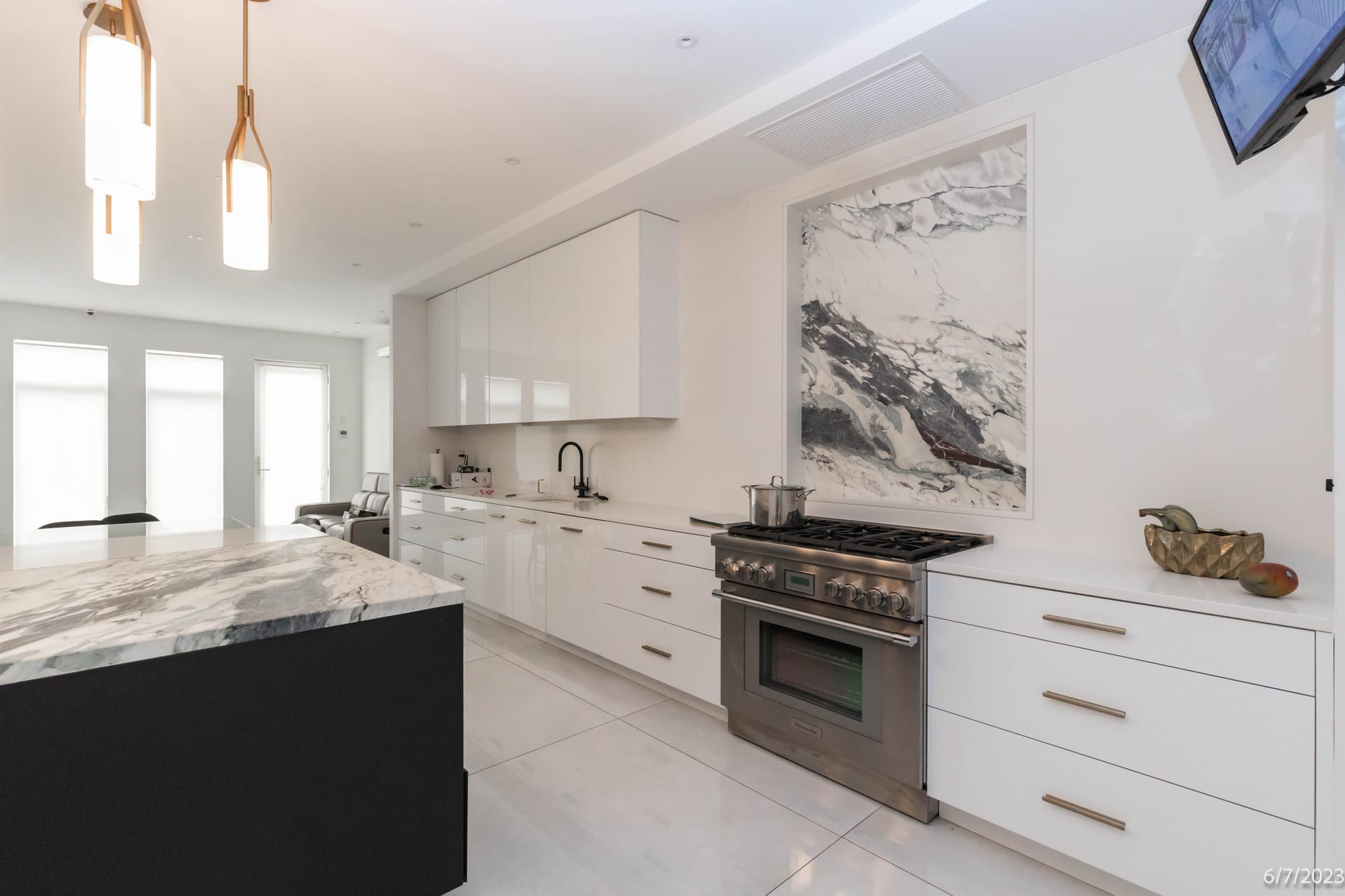 Interior kitchen with marble island and stainless range inside a New York City residence adjoining a demolition site, photographed room by room for an OpenDoors360 pre-demolition survey.